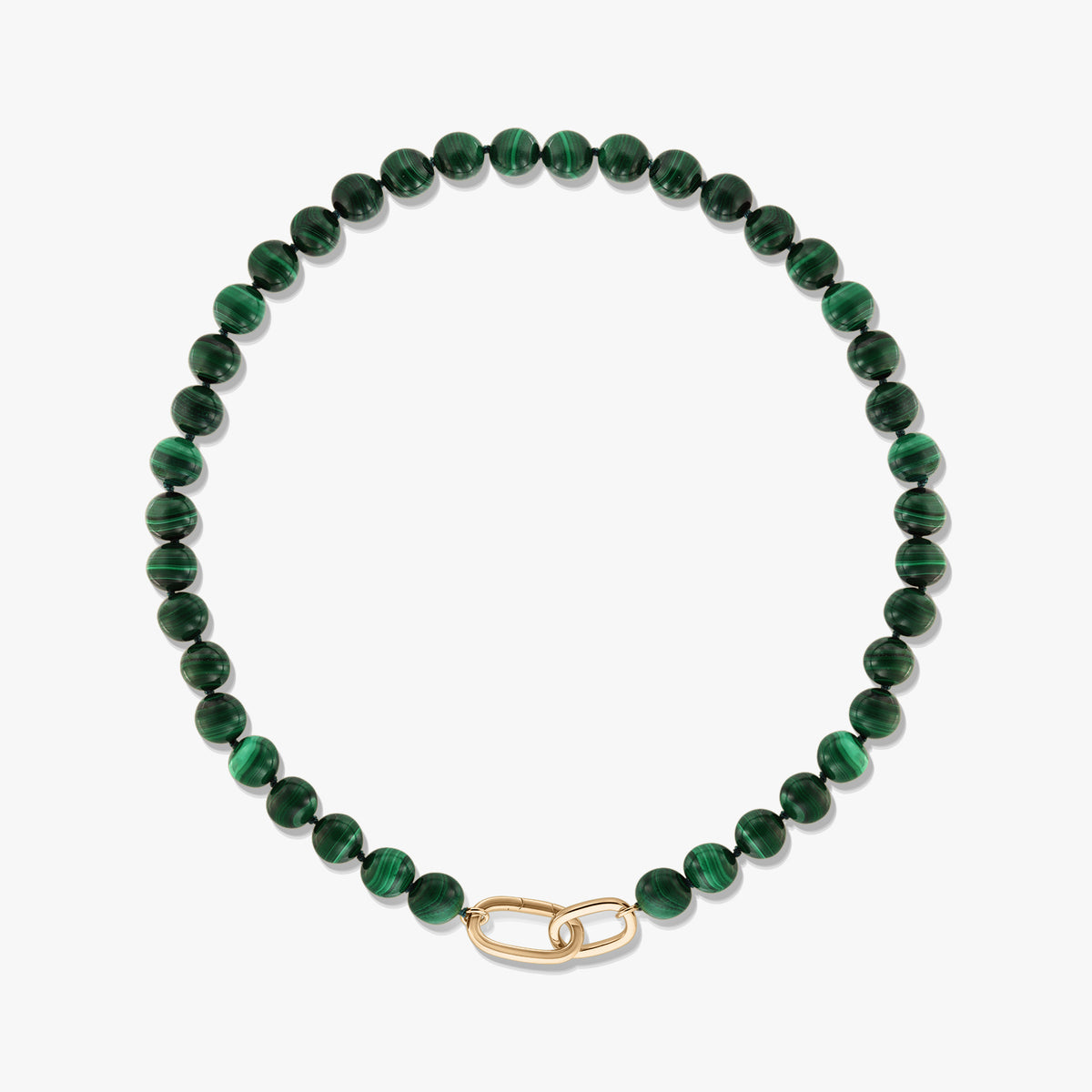 Zielony naszyjnik z koralików malachitu z zapięciem w kształcie spinacza wykonanym ze srebra sterling pokrytego złotem na białym tle.