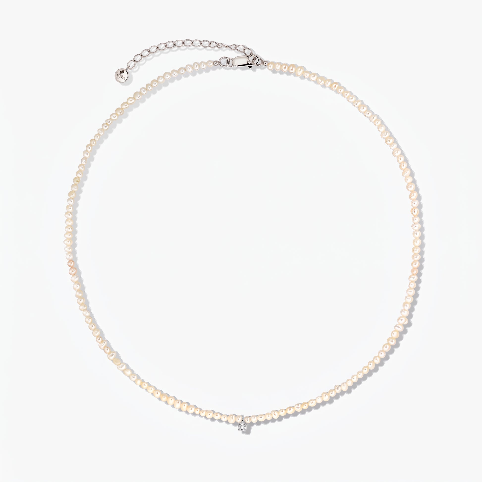 Srebrny naszyjnik Fairy z małymi perłami hodowlanymi i regulowanym łańcuszkiem przedłużającym, sfotografowany na białym tle.