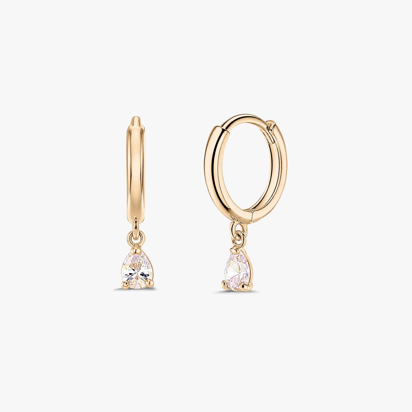 Para eleganckich kolczyków typu huggie z żółtego złota 14K z wiszącymi kroplami z białej cyrkonii w szlifie gruszki, na białym tle.