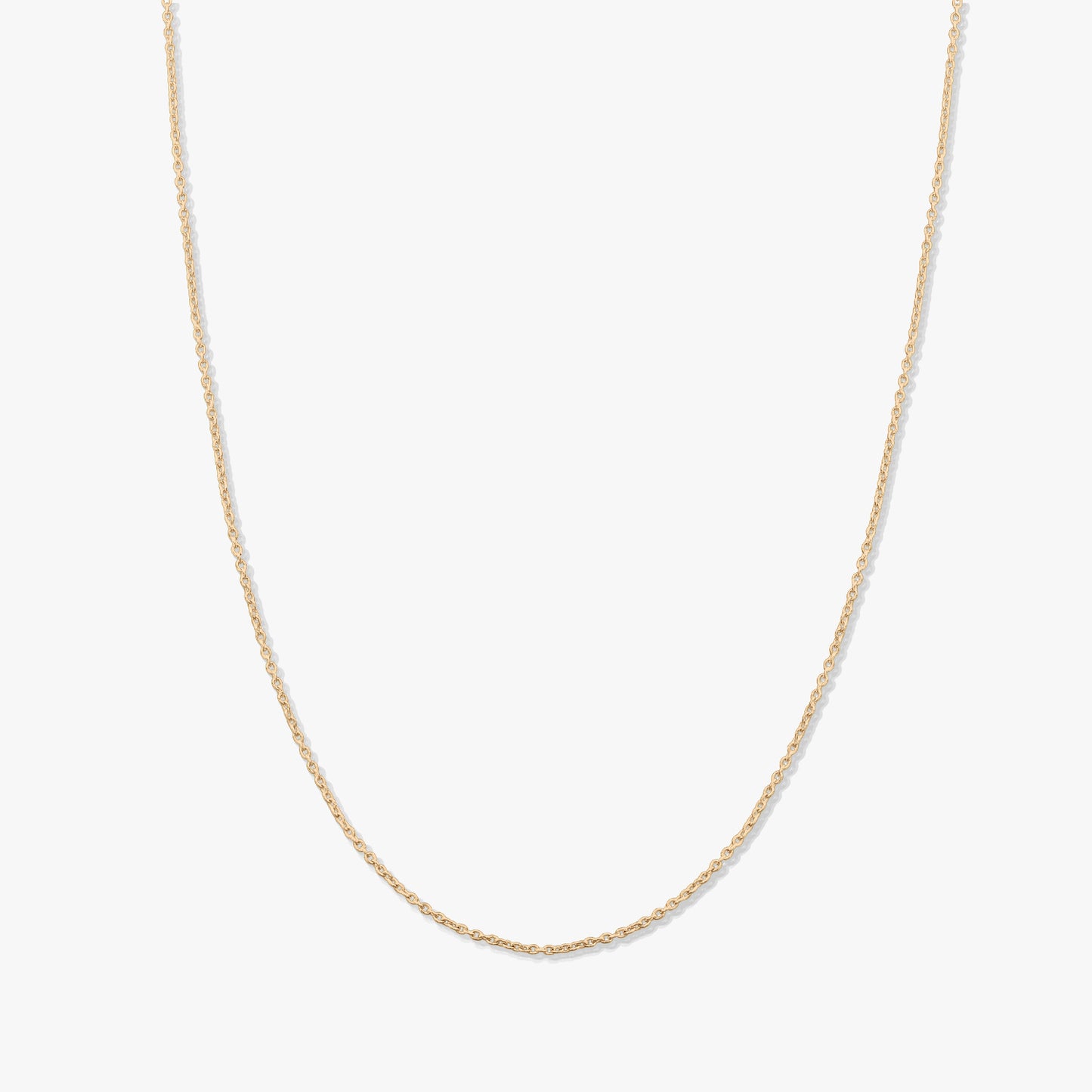 Minimalistyczny naszyjnik łańcuszek z 14K żółtego złota na jednolitym białym tle.