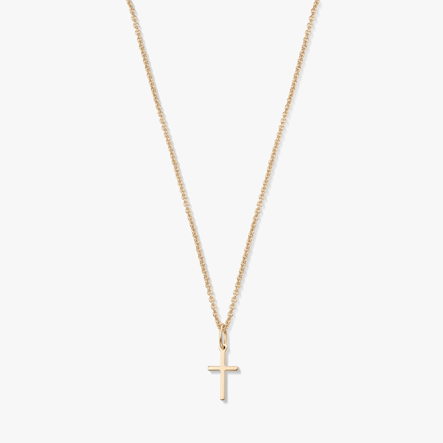 Minimalistyczny naszyjnik z żółtego złota 14K z małą zawieszką w kształcie krzyżyka na delikatnym łańcuszku, na białym tle.