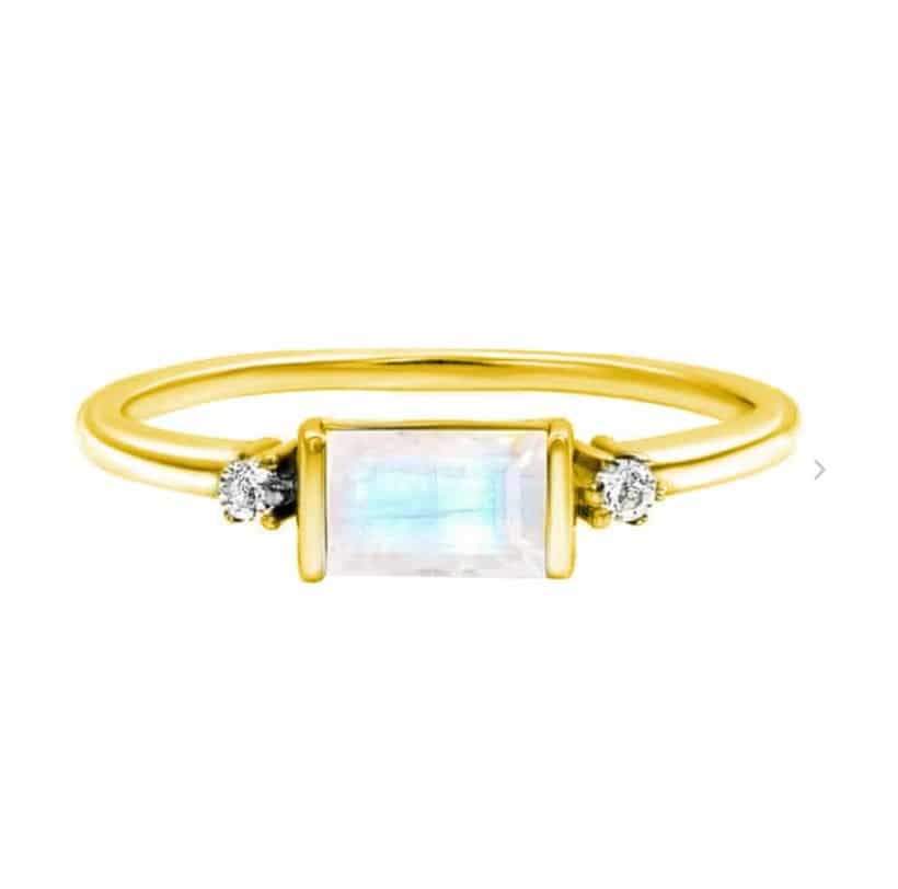 Złoty pierścionek Eva ze srebra z kamieniem księżycowym i cyrkoniami, z prostokątnym kamieniem księżycowym i dwoma cyrkoniami na złoconej srebrnej obrączce.