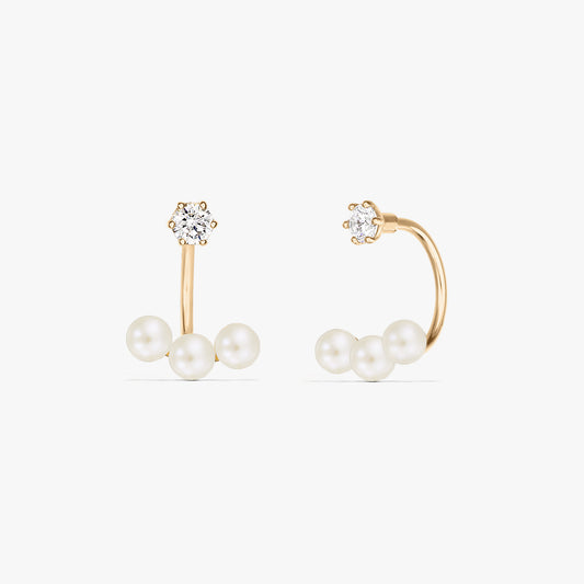 Kwadratowe zdjęcie produktu: para kolczyków typu ear jacket z 14K żółtego złota, z trzema naturalnymi perłami pod małym, okrągłym sztyftem, na czystym białym tle.