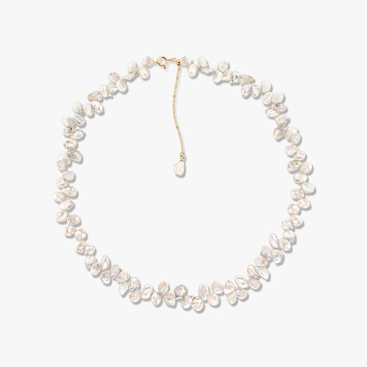 Golden Brielle cultured pearl necklace with irregular baroque pearls and a gold‑tone chain extender on a white background.