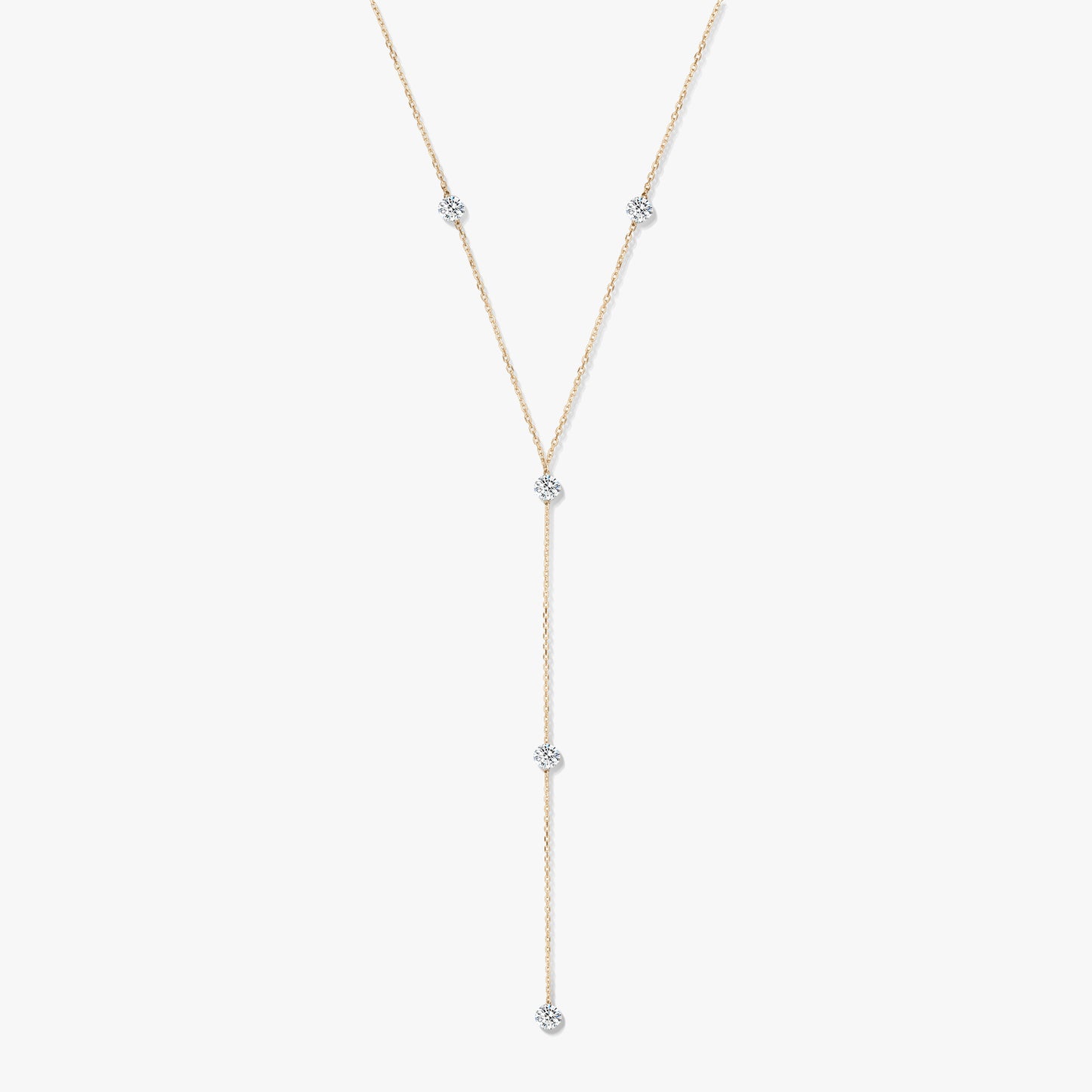 Naszyjnik typu lariat z żółtego złota 14K z pięcioma okrągłymi diamentami w oprawie typu bezel na białym tle.