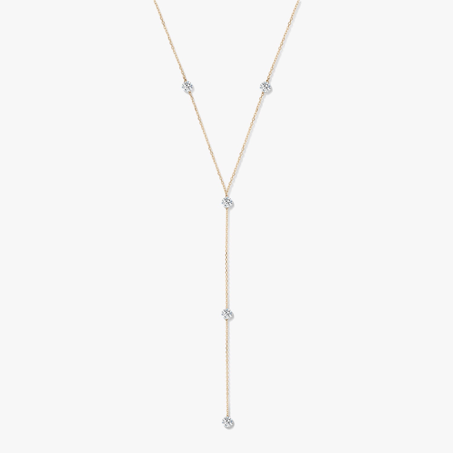 Naszyjnik typu lariat z żółtego złota 14K z pięcioma okrągłymi diamentami w oprawie typu bezel na białym tle.