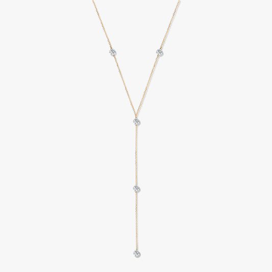 Naszyjnik typu lariat z żółtego złota 14K z pięcioma okrągłymi diamentami w oprawie typu bezel na białym tle.