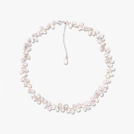 Sterling silver necklace strung with irregular baroque cultured white pearls, arranged in a circle on a white background with an adjustable chain and a dangling pearl charm.