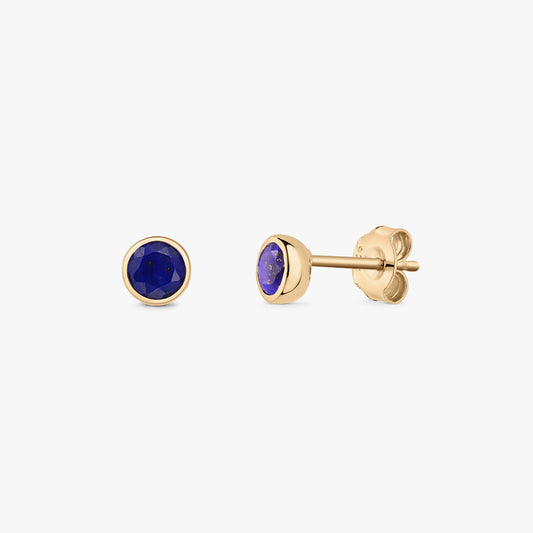 Okrągłe kolczyki sztyfty z lapis lazuli w oprawie typu bezel, z pozłacanego srebra 925, pokazane z przodu i z boku, z zapięciami typu motylek na białym tle.