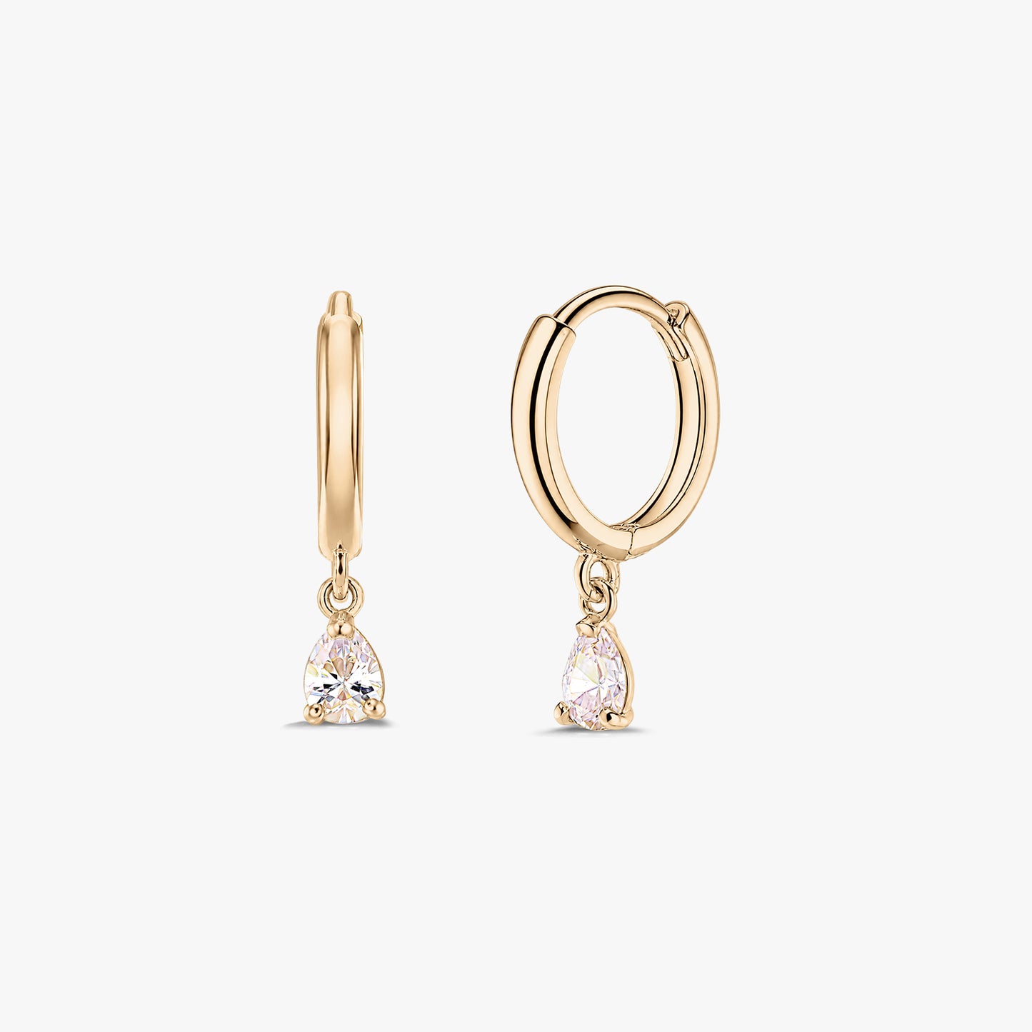 Para eleganckich kolczyków typu huggie z żółtego złota 14K z wiszącymi kroplami z białej cyrkonii w szlifie gruszki, na białym tle.