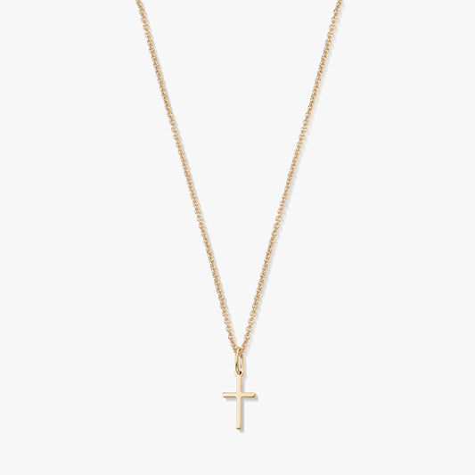 Minimalistyczny naszyjnik z żółtego złota 14K z małą zawieszką w kształcie krzyżyka na delikatnym łańcuszku, na białym tle.